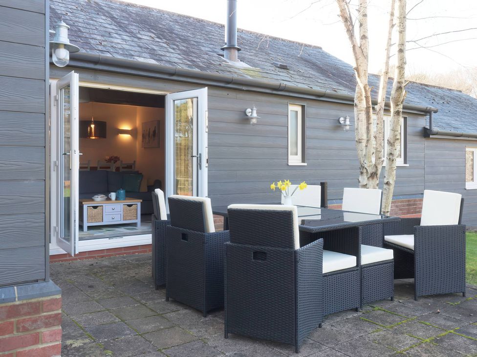 An outdoor dining area with a table and chairs at TBC 