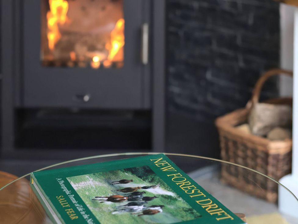 A living room with a fireplace and a book on a table at TBC