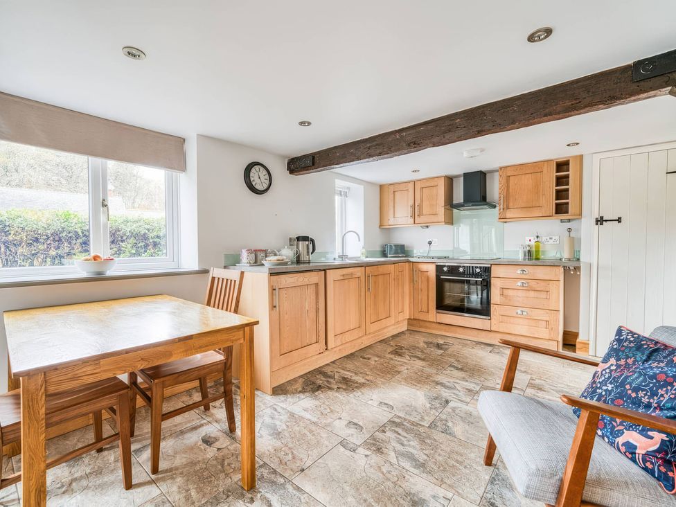 A kitchen with wooden cabinets and a dining table at TBC