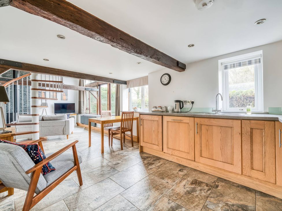 A kitchen with a wooden table and chairs at TBC in 