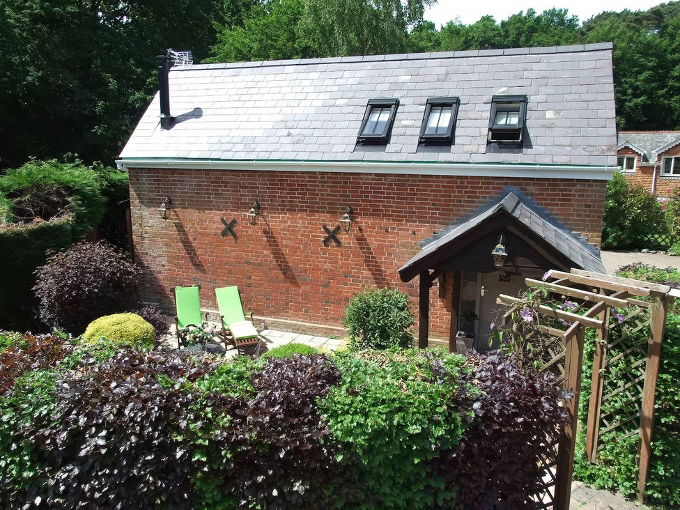 An outdoor area with green chairs and a brick wall at TBC