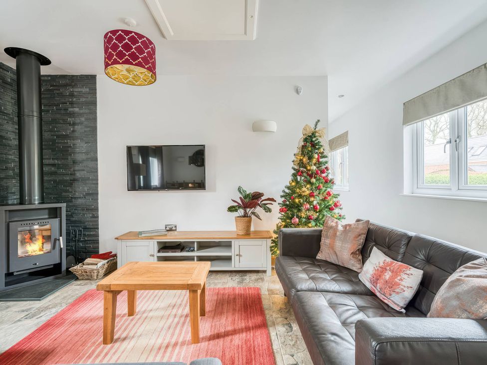 A living room with a sofa, coffee table, and television at TBC in 