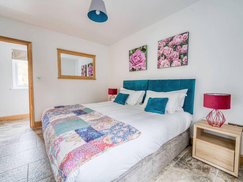 A bedroom with a bed and wall pictures at TBC