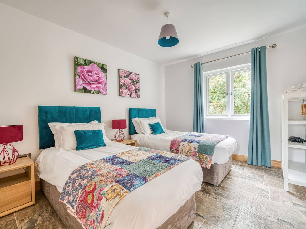A bedroom with two beds and wall art at TBC
