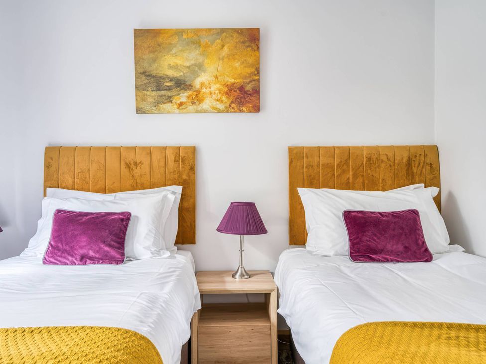 A bedroom with two beds and a painting at TBC in 