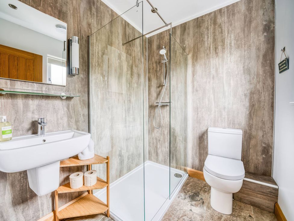 A bathroom with a shower, sink, and toilet at TBC