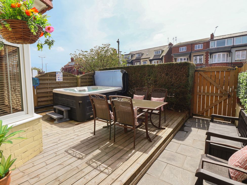 An outdoor area with a hot tub and a dining set at Tapestry House in Bridlington