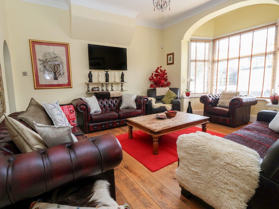 A living room with leather sofas and a wooden coffee table at Tapestry House in Bridlington