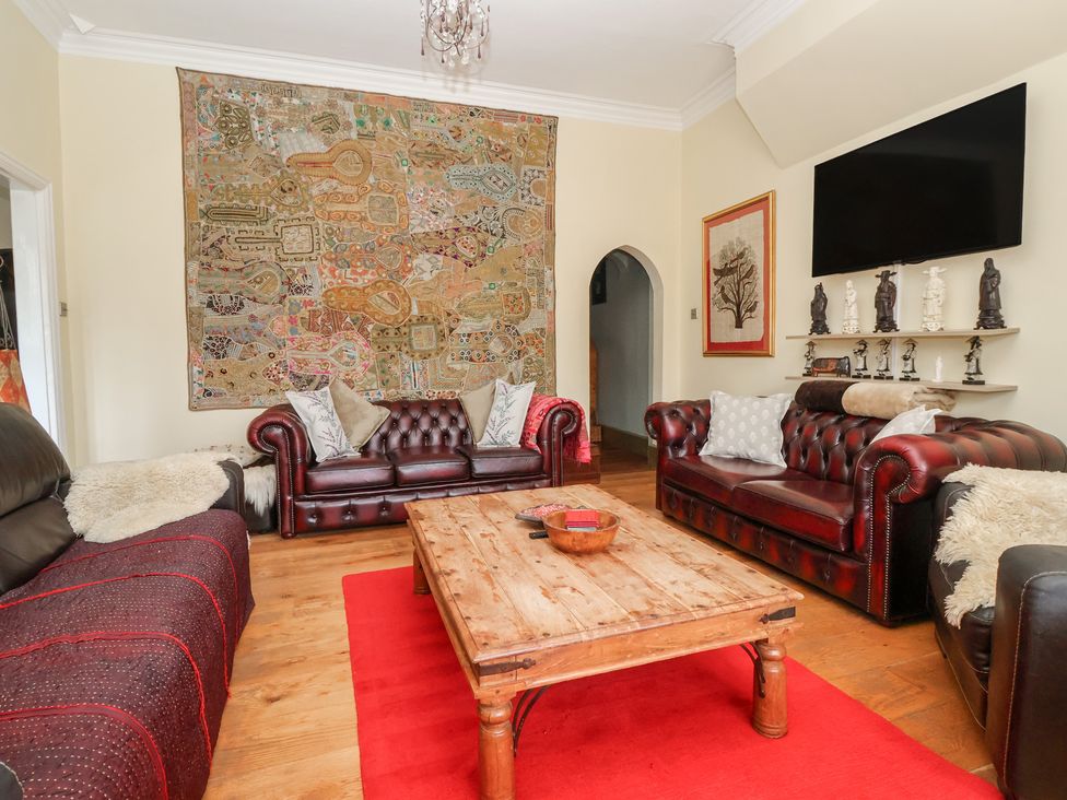 A living room with a tapestry and leather sofas at Tapestry House in Bridlington