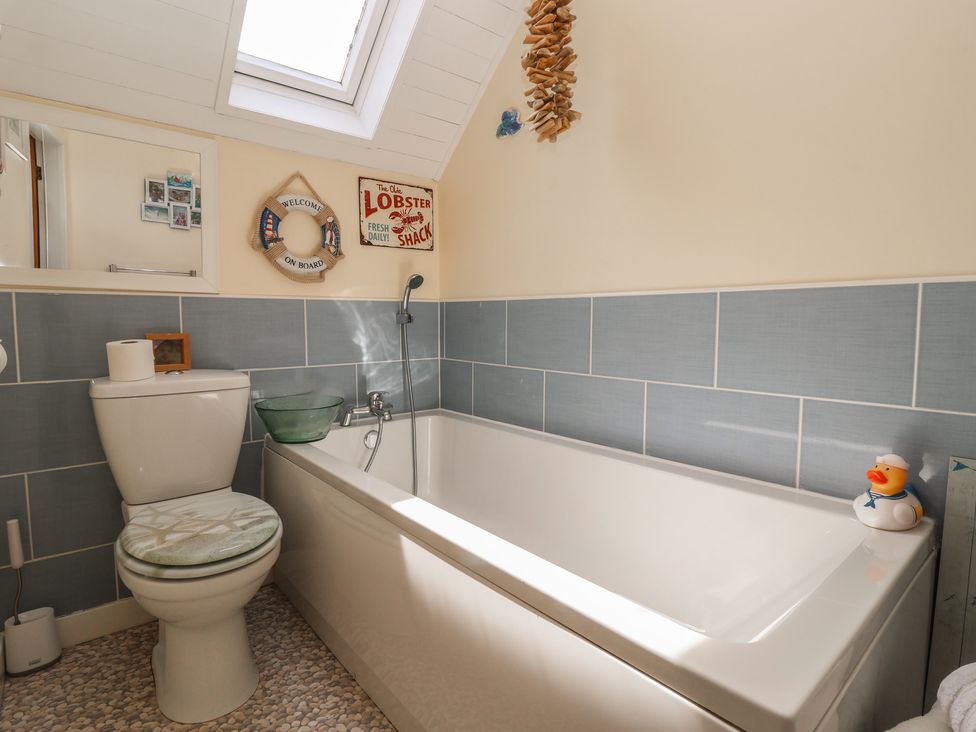 A bathroom with a bathtub, toilet, and sink at Tapestry House in Bridlington