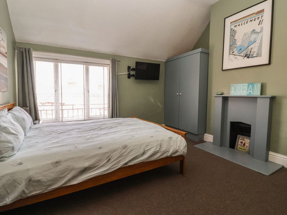 A bedroom with a bed and wardrobe at Tapestry House in Bridlington