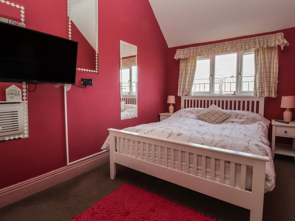 A bedroom with a bed and television at Tapestry House in Bridlington