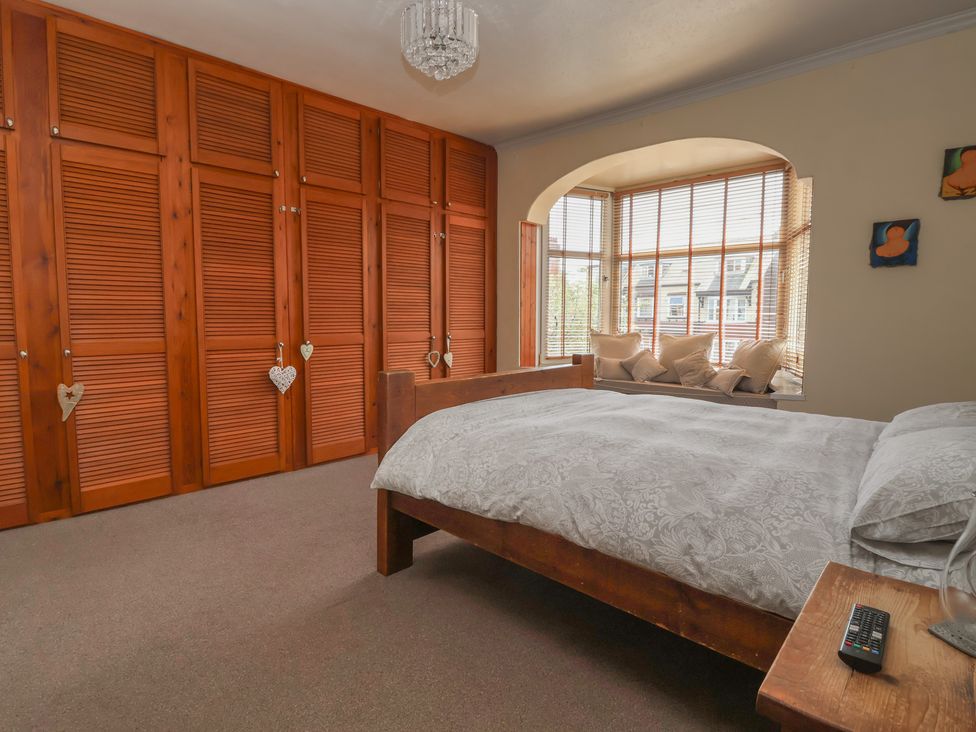 A bedroom with a bed and wardrobe at Tapestry House in Bridlington