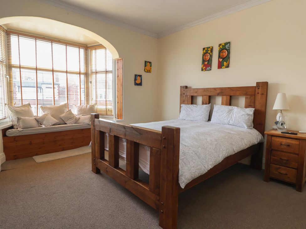 A bedroom with a bed and a window seat at Tapestry House in Bridlington