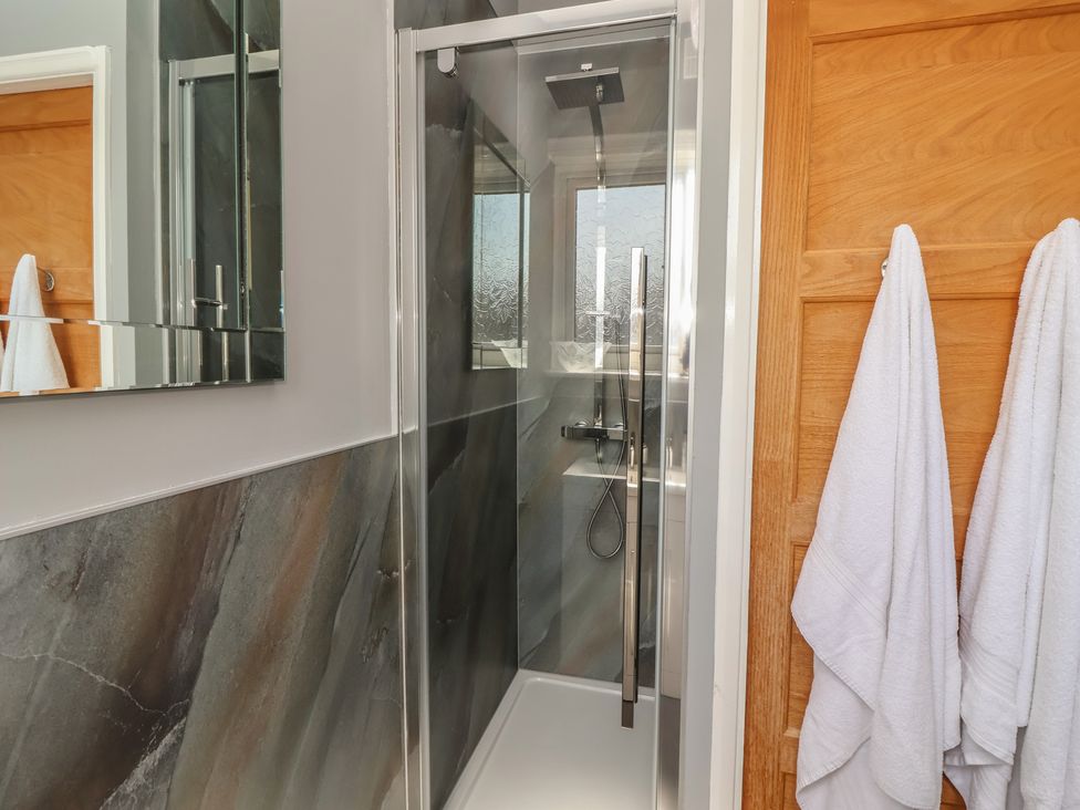 A bathroom with a shower and towels hanging at Tapestry House in Bridlington