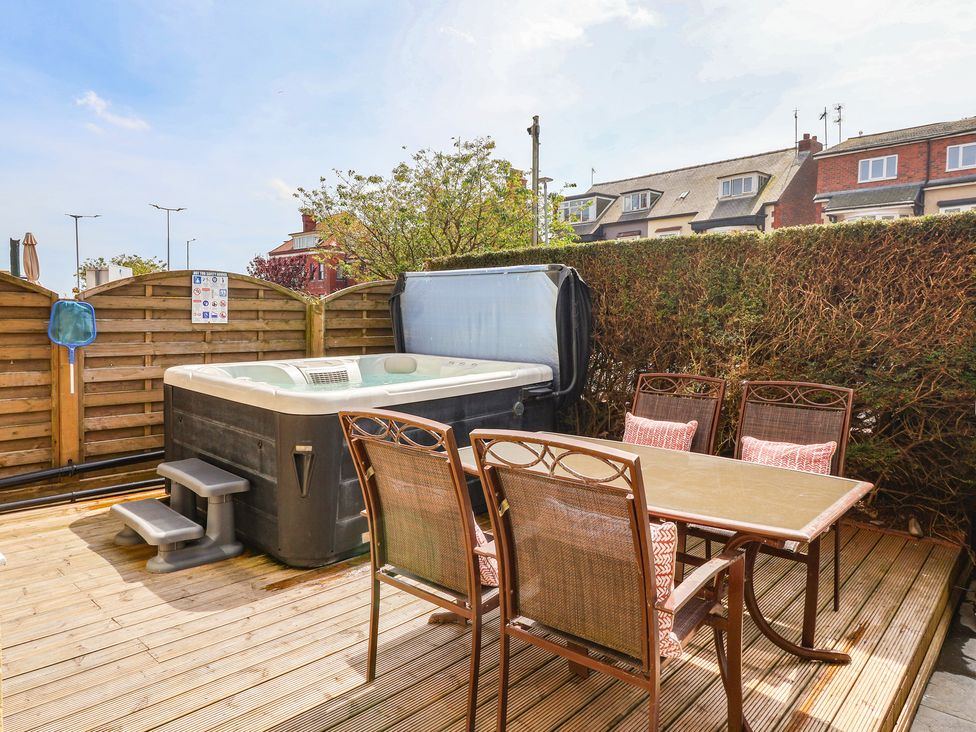 A garden with a hot tub and table with chairs at Tapestry House in Bridlington