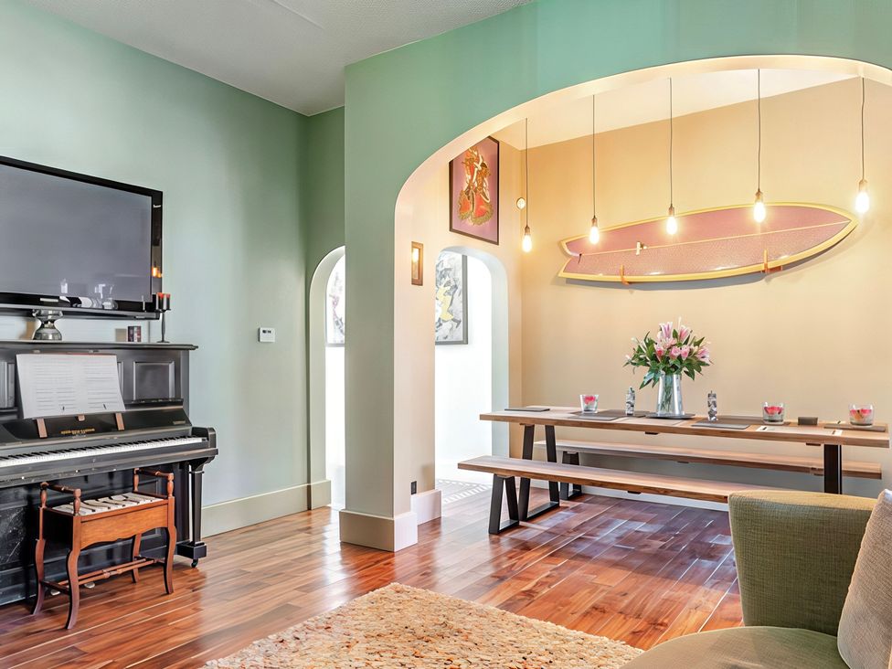 A dining room with a piano and dining table at Tapestry House in Bridlington