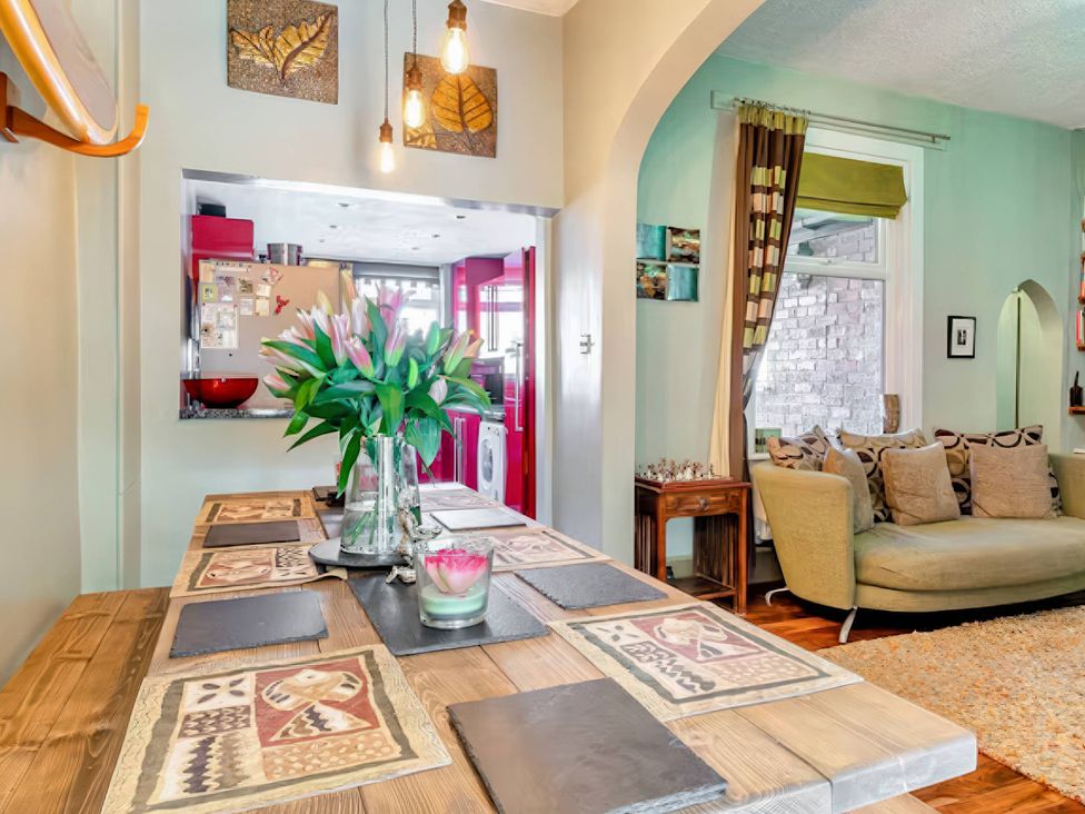 A dining room with a large table and flowers at Tapestry House in Bridlington
