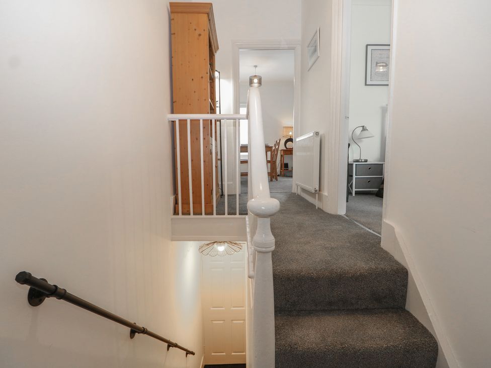 A staircase with a handrail leading to a hallway at Foreshore in Deal