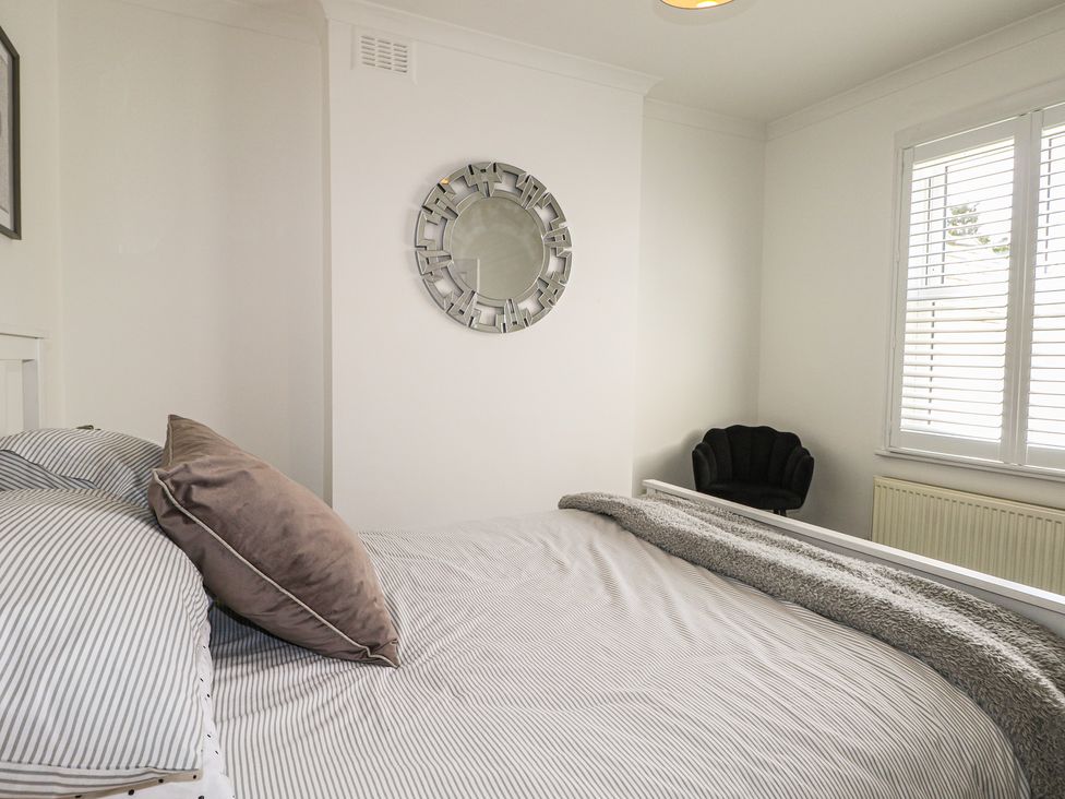 A bedroom with a bed and a mirror at Foreshore in Deal