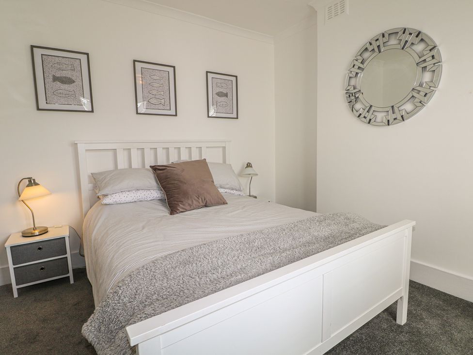 A bedroom with a bed and nightstand at Foreshore in Deal
