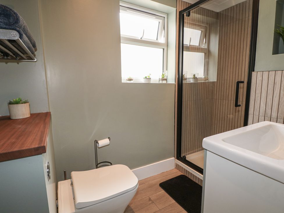A bathroom with a toilet, shower, and sink at Foreshore in Deal