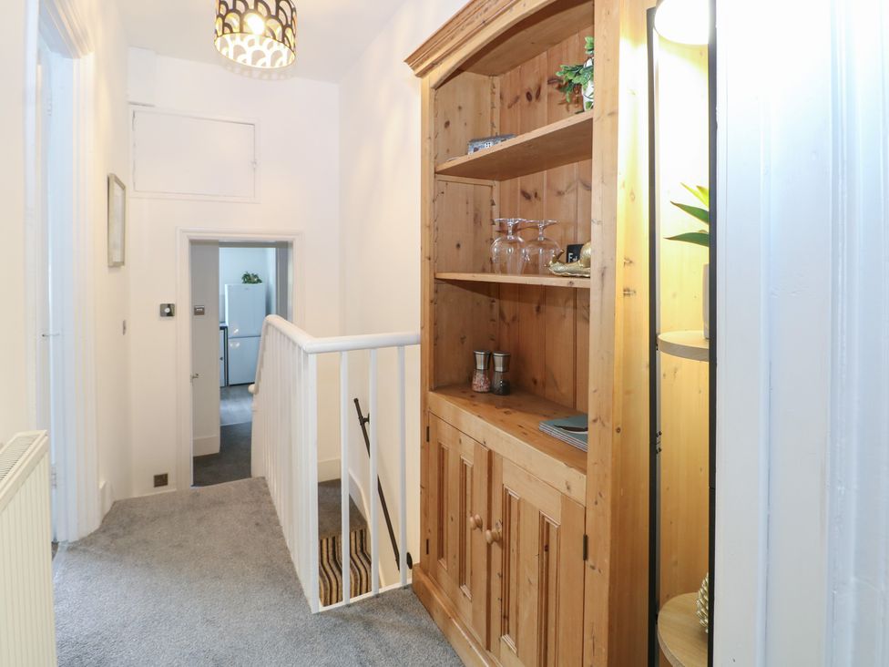 A hallway with a bookshelf and door at Foreshore in Deal