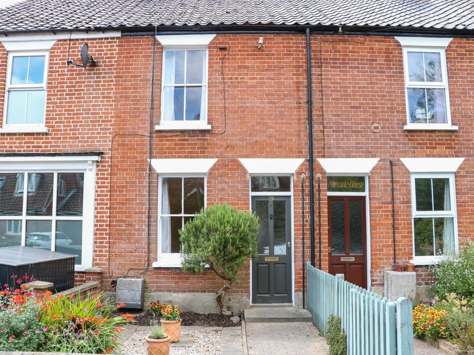 A brick facade with windows and flower beds at 19 Covert Road in Reydon