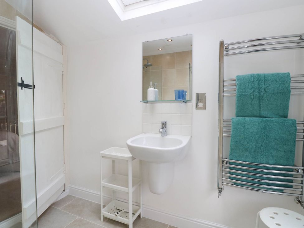 A bathroom with a sink and towels on a rail at 19 Covert Road in Reydon