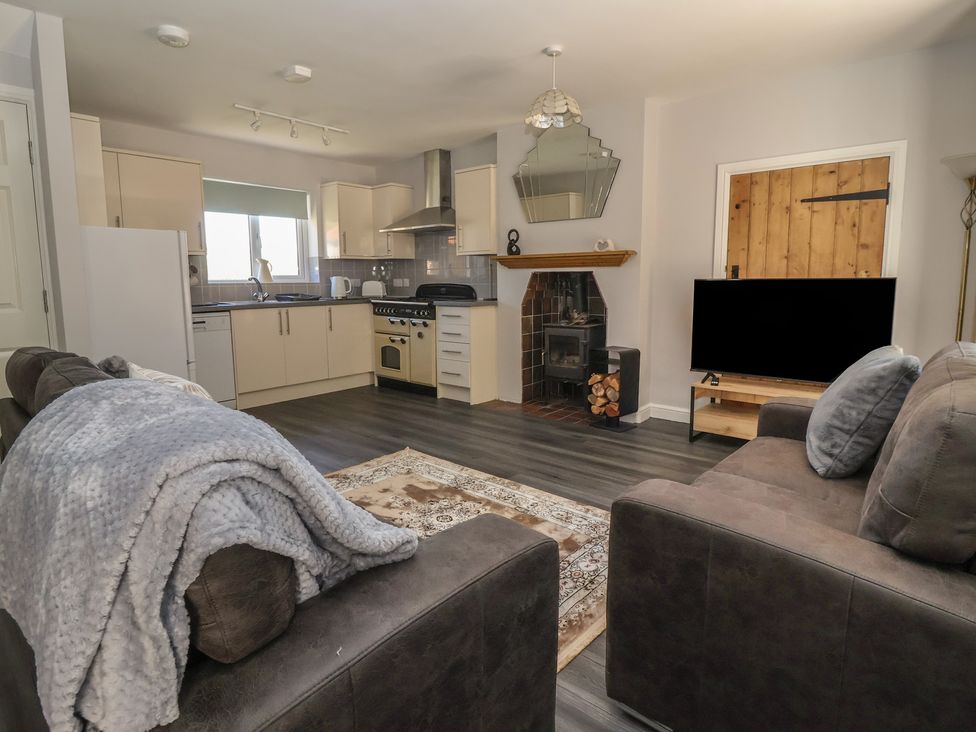 A living room with kitchen area and fireplace at Sea View in Scarborough