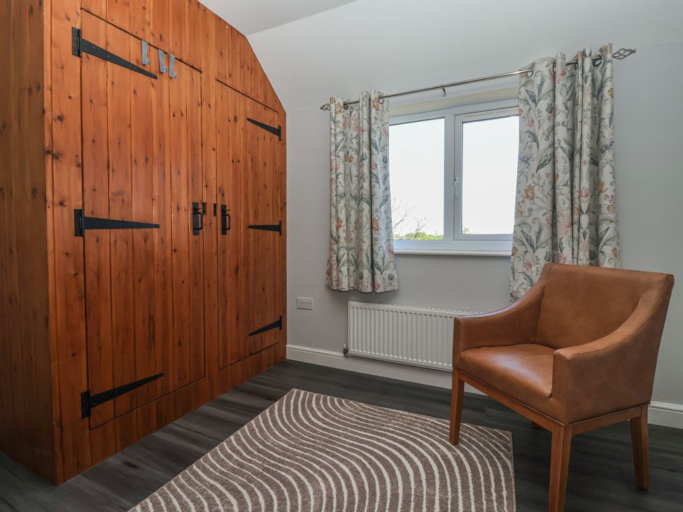 A bedroom with a wardrobe and window at Sea View in Scarborough