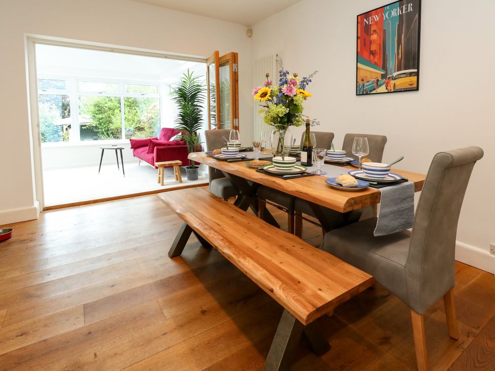 A dining room with a wooden table and benches at 29 Bincleaves Road, Weymouth