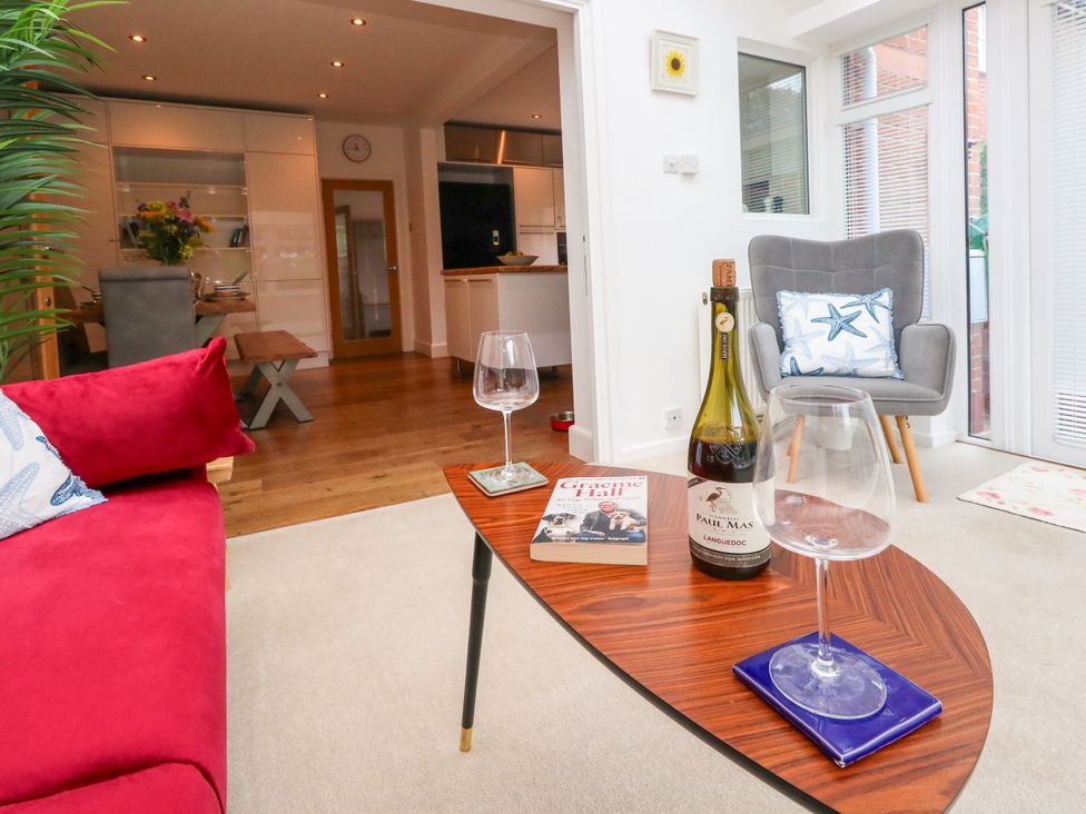 A living room with a wine bottle and glasses on a table at 29 Bincleaves Road, Weymouth