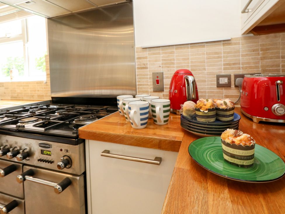 A kitchen with mugs on a counter and cupcakes on plates at 29 Bincleaves Road in Weymouth