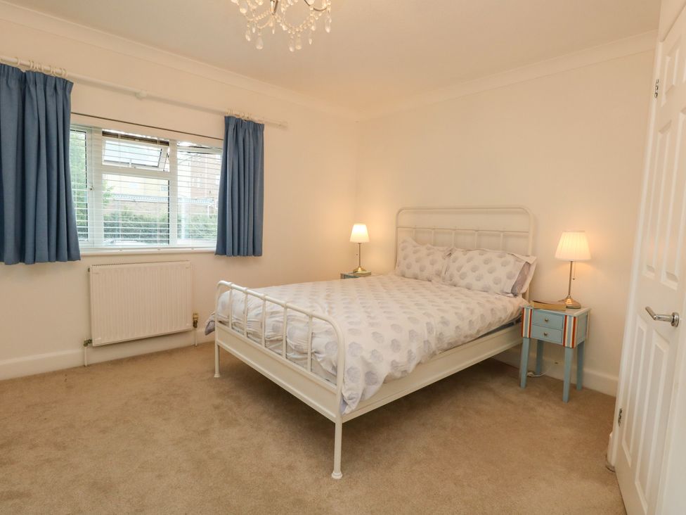 A bedroom with a bed, curtains, and a window at 29 Bincleaves Road in Weymouth