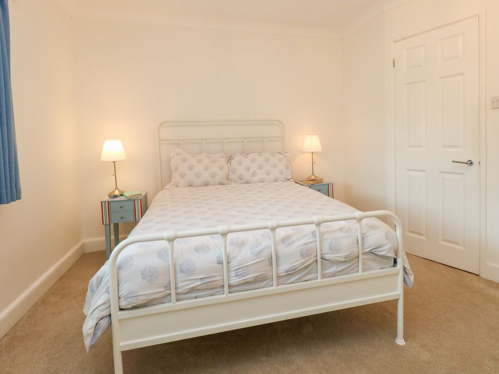 A bedroom with a bed, nightstand, and lamp at 29 Bincleaves Road, Weymouth