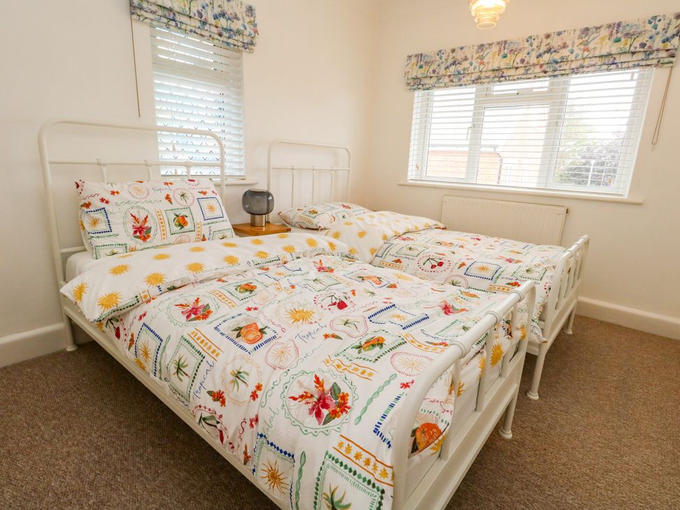 A bedroom with two single beds and a lamp at 29 Bincleaves Road in Weymouth