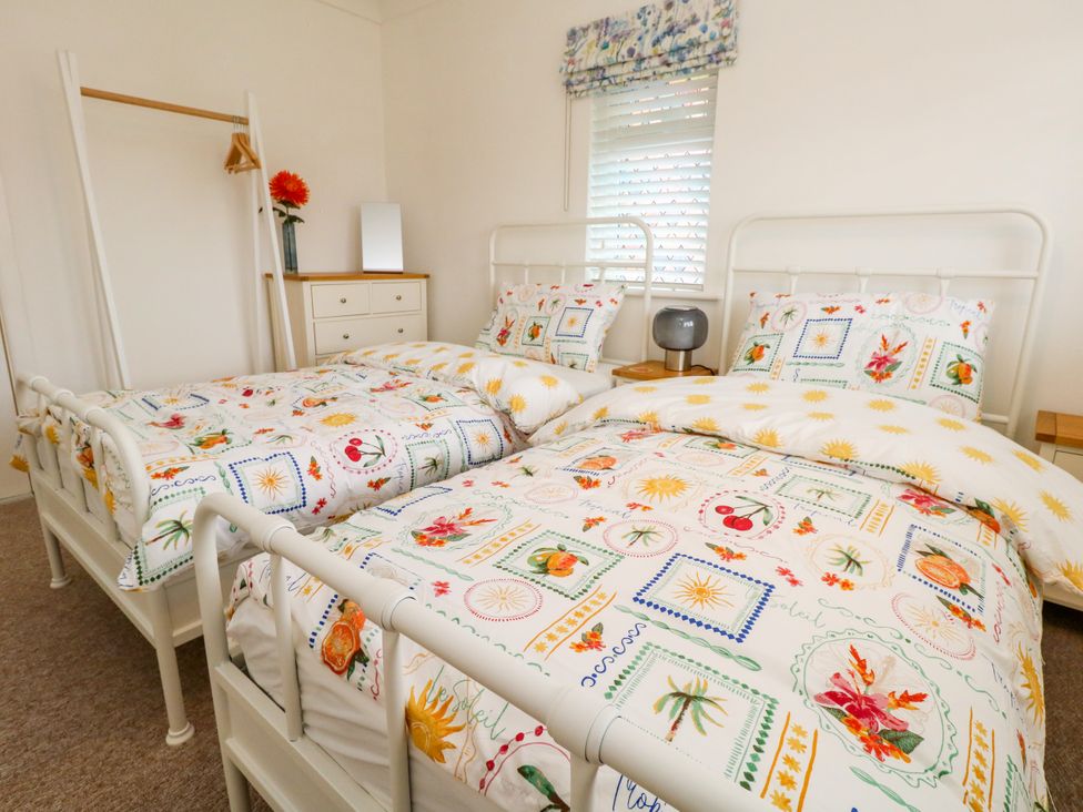 A bedroom with two beds and a nightstand at 29 Bincleaves Road Weymouth