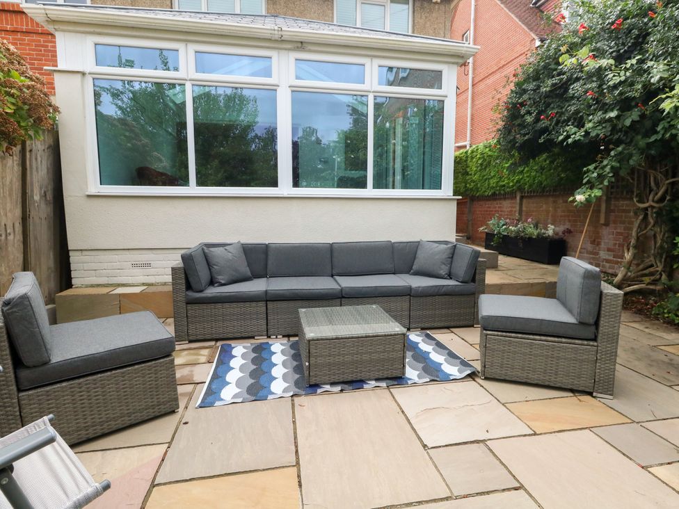 A garden with a sectional sofa and a coffee table at 29 Bincleaves Road Weymouth