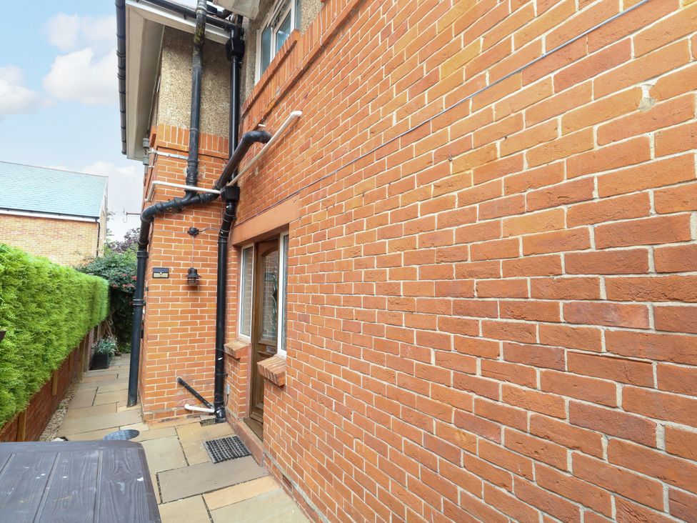 An outdoor pathway alongside a brick wall and window at 29 Bincleaves Road Weymouth
