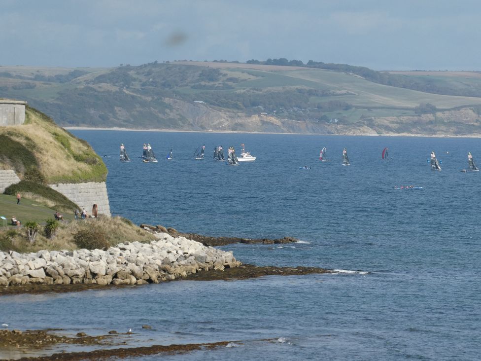 A view of water with sailboats and people along the shore at Coast Path Cottage Weymouth