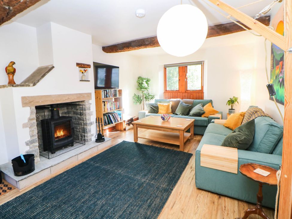 A living room with a fireplace and couch at Stone Lily Cottage