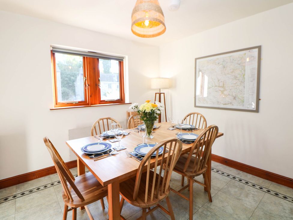 A dining room with a table set for six at Stone Lily Cottage