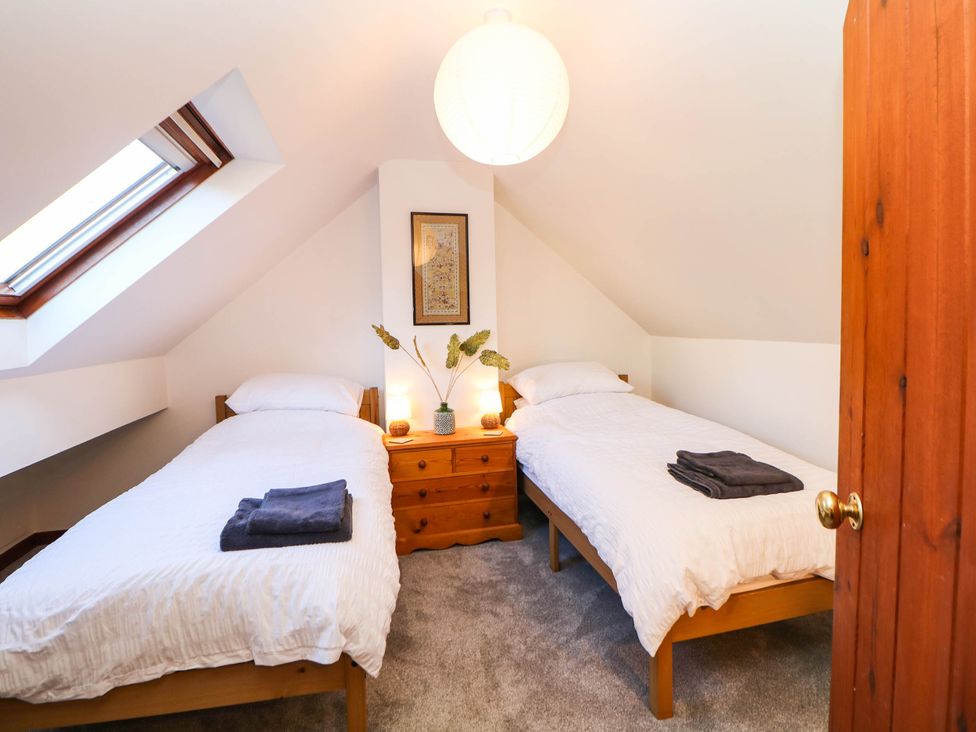 A bedroom with two twin beds and a window at Stone Lily Cottage