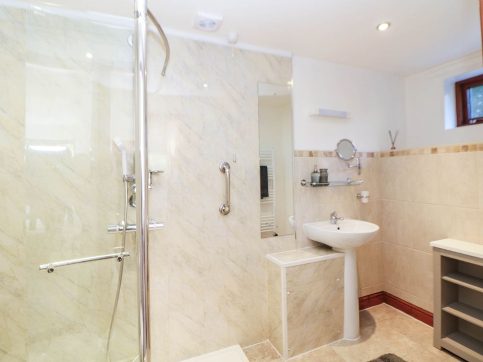 A bathroom with a shower and sink at Stone Lily Cottage