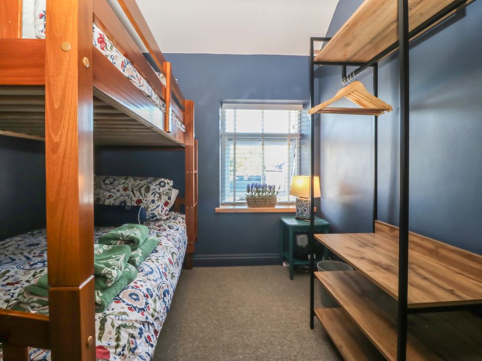 A bedroom with a bunk bed and shelving at Foxglove Cottage in Conwy