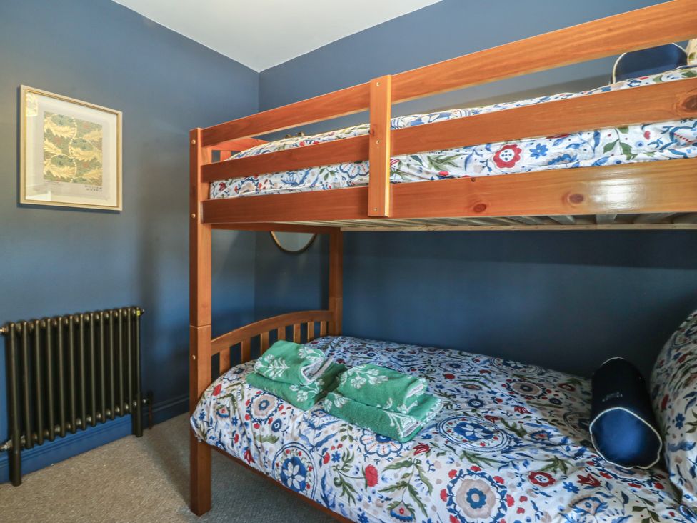 A bedroom with a bunk bed and towels at Foxglove Cottage in Conwy