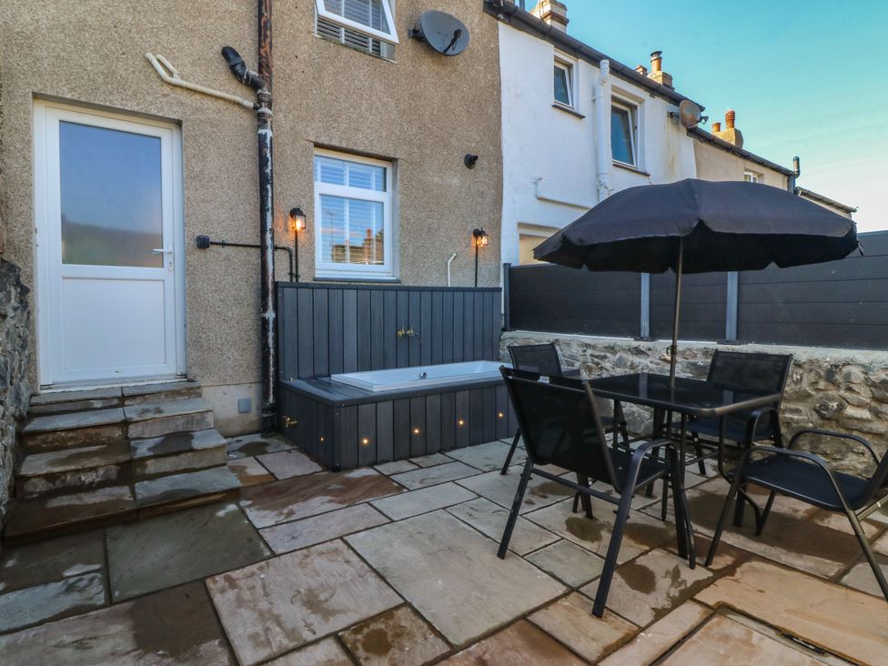 A garden with a hot tub and seating area at Foxglove Cottage in Conwy