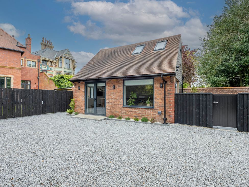 A house with a gravel driveway and fence at Blackwood, Hornsea