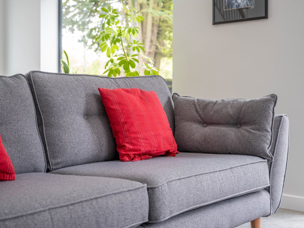 A sofa with red cushions in a living room at Blackwood in Hornsea